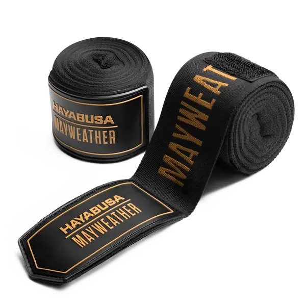 De Hayabusa Mayweather Bandages Zwart Goud combineren luxe en prestatie. Deze elastische handwraps bieden optimale ondersteuning en polsstabiliteit tijdens bokstrainingen, met een stijlvol zwart-gouden design geïnspireerd door kampioenen.