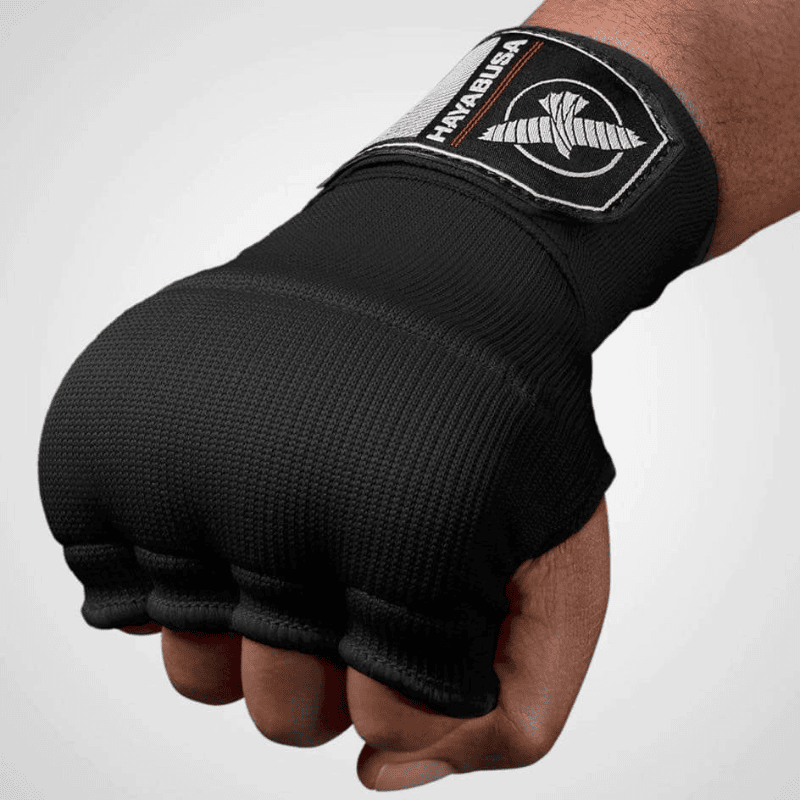 Bovenste weergave van een gebalde vuist met een zwarte Hayabusa Quick Gel Wrap binnenhandschoen.