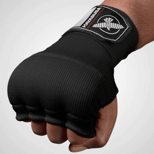 Bovenste weergave van een gebalde vuist met een zwarte Hayabusa Quick Gel Wrap binnenhandschoen.