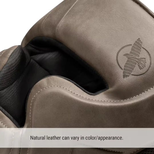 Close-up van een bruine Hayabusa bokshoofdbeschermer met logo in het leer gegraveerd en zichtbare stiknaden, gemaakt van natuurlijk leer.