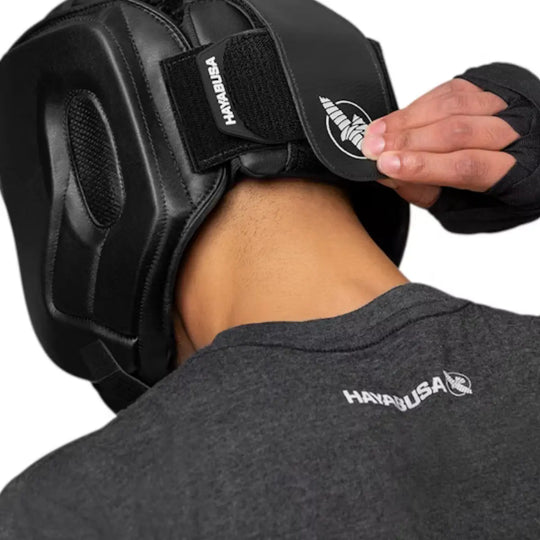 Man past zwarte Hayabusa hoofdbeschermer aan met klittenbandsluiting aan de achterkant