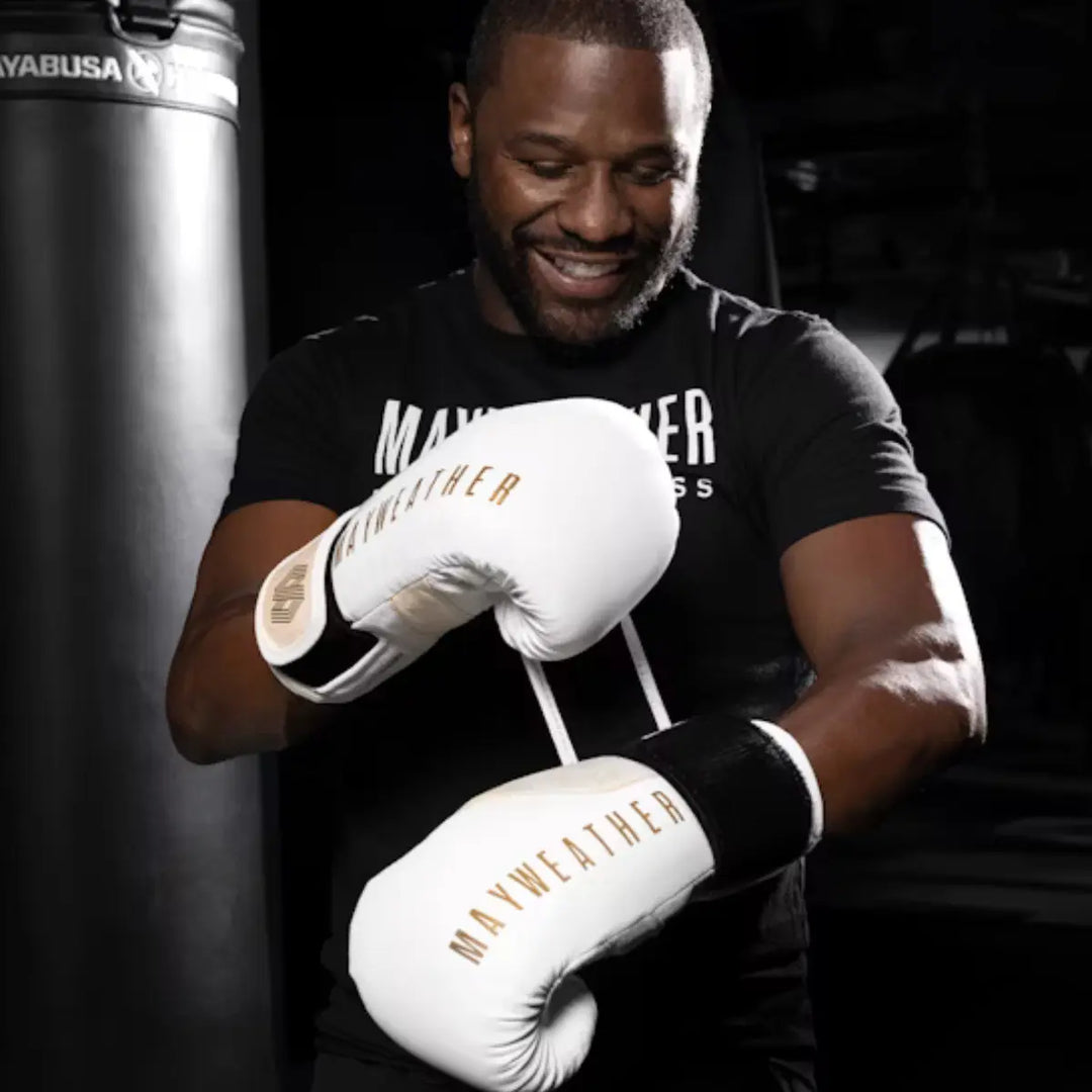 Een close-up van een zwarte Marvel x Hayabusa boks- of MMA-handschoen met het Venom-symbiotisch design. De handschoen toont rode en bruine 'schubben' op de rug en een rood gevoerde binnenkant met het Marvel logo op de pols.