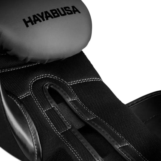 Detailfoto van zwarte Hayabusa bokshandschoen met grijs bovenkant en witte stiksels, het Hayabusa logo is zichtbaar.