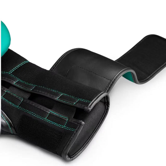 Close-up van de klittenbandsluiting en polsband van een Hayabusa bokshandschoen in turquoise met zwarte details, model S4, met zichtbare turquoise stiknaden.