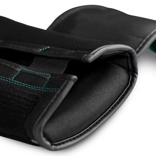 Close-up van de polsband van een zwarte bokshandschoen met klittenband en opvallende turquoise stiknaden, met zichtbare textuur van het materiaal en de afwerking.
