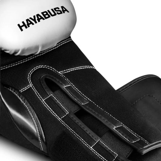 Close-up van witte en zwarte Hayabusa bokshandschoen met open palm en stevige stiksels.