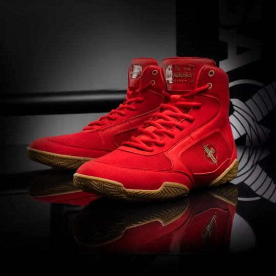 Rode Hayabusa boksschoenen met bruine zolen, gepresenteerd op glanzende zwarte ondergrond met Hayabusa logo.