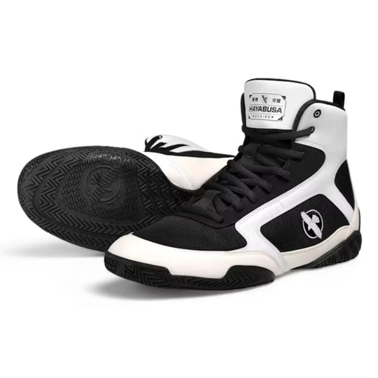 Zwarte en witte Hayabusa boksschoenen, met zwarte zolen en Hayabusa logo zichtbaar op de zijkant en zool.