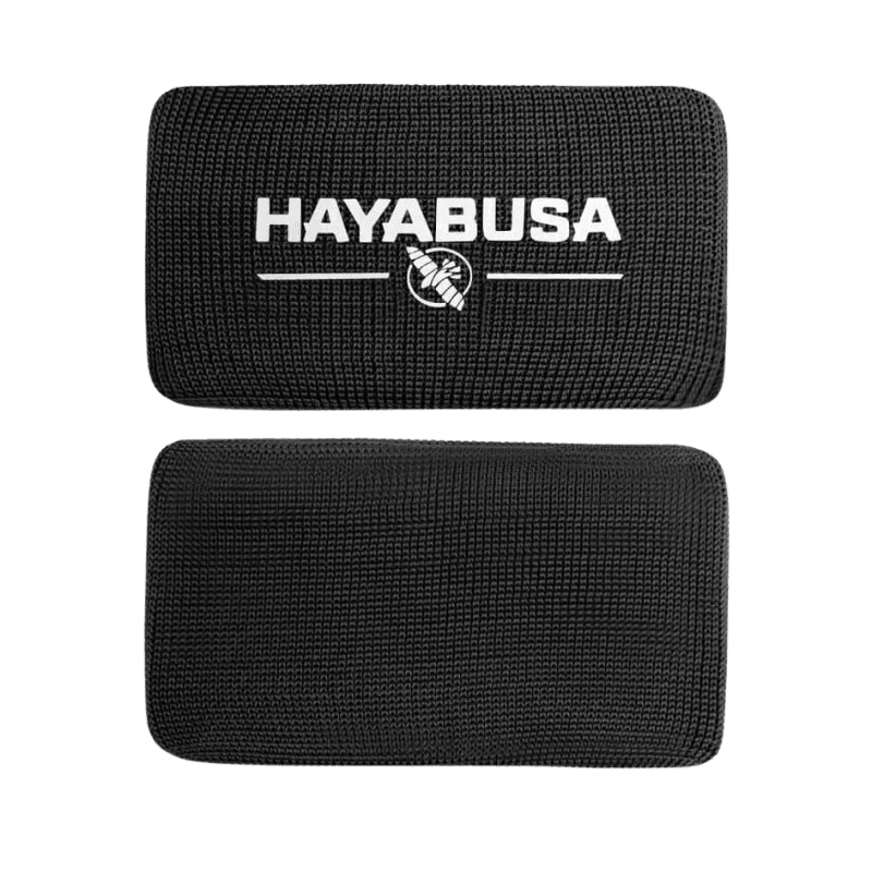 Een enkele zwarte Hayabusa Boxing Knuckle Guard met een zichtbaar wit Hayabusa-logo en adelaarsembleem, gepresenteerd tegen een donkere achtergrond.