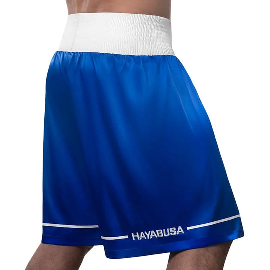 Rear view of blue Hayabusa boxing shorts with a wide white elastic waistband and subtle white trim near the hem. The smooth, lightweight fabric drapes comfortably for unrestricted movement, while the Hayabusa logo at the back adds a clean, professional finish ideal for boxing training and competition.