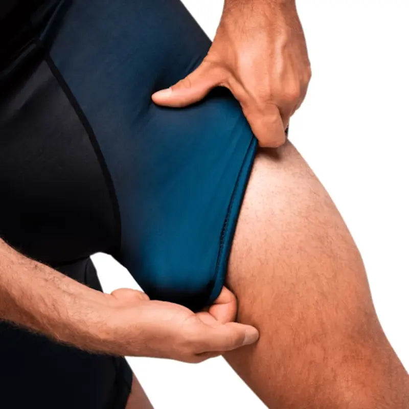 Close-up van zwarte Hayabusa compressieshort met blauwe stretchstof, getoond terwijl de stof bij het dijbeen wordt uitgerekt.