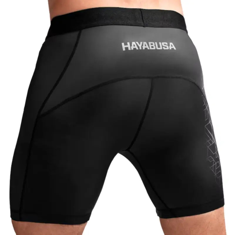 Achterzijde van zwarte Hayabusa compressieshort met wit logo op de tailleband, strakke pasvorm en subtiele grafische details.