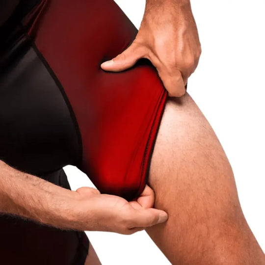 Close-up van rode Hayabusa compressieshort, sporter trekt de pijp iets omhoog om de elasticiteit en pasvorm van het materiaal te tonen.