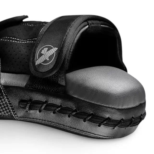 Detailfoto van Hayabusa focus mitts in zwart met grijze padding en stevige klittenbandsluiting voor stabiele pasvorm tijdens bokstraining.