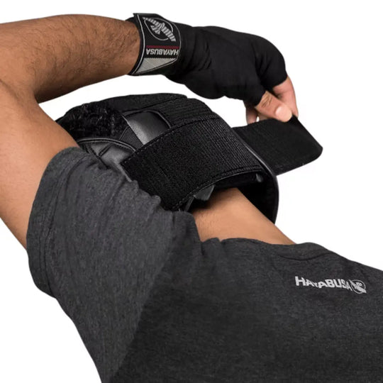 Man zet zwarte Hayabusa hoofdbeschermer vast met verstelbare klittenbandsluiting