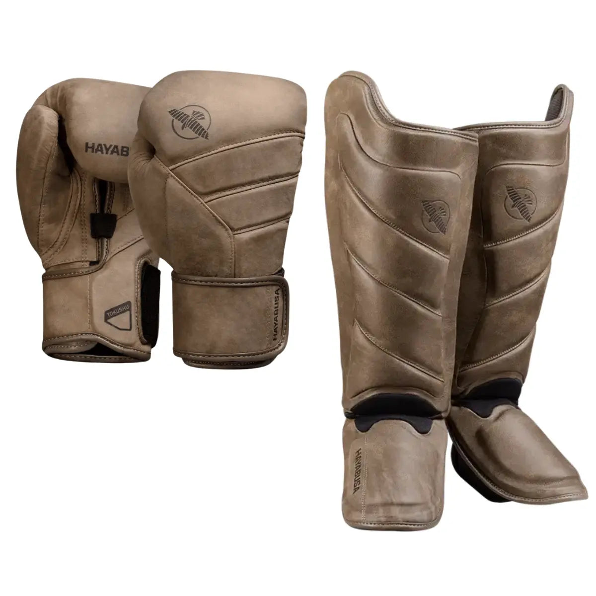 Hayabusa set bestaande uit bruine bokshandschoenen en bijpassende bruine scheenbeschermers met Hayabusa logo, beide van leer met stoere afwerking.