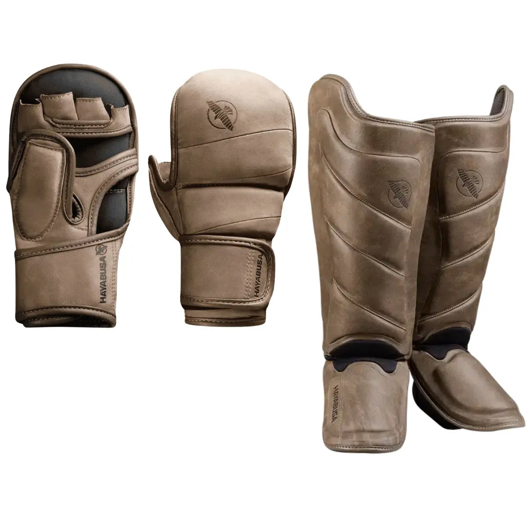 Hayabusa set bestaande uit bruine MMA handschoenen met open handpalm en bijpassende bruine scheenbeschermers met Hayabusa logo.