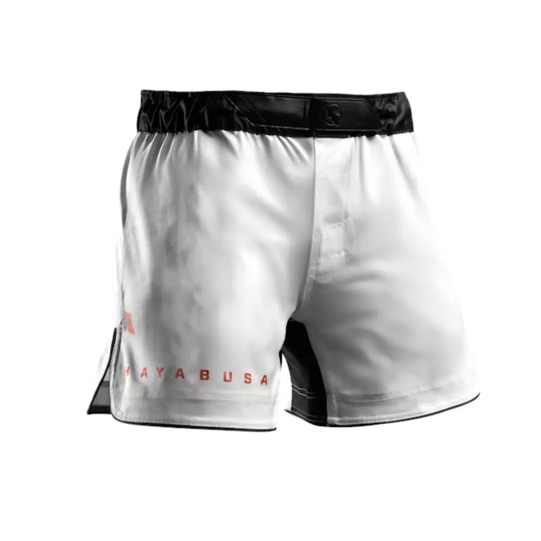 Vooraanzicht van witte Hayabusa fightshorts met zwarte tailleband en rode merkopdruk langs de pijp.