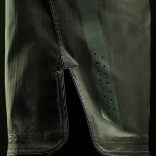 Close-up van groene Hayabusa MMA fightshorts met zijsplit, verstevigde naden en geperforeerde ventilatiestrook.