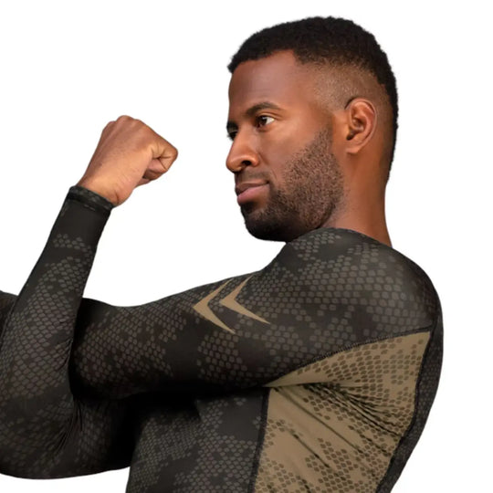 Zijkant van de Hayabusa Ranked Long Sleeve Rash Guard in bruin, met focus op het ademende materiaal en de logo’s