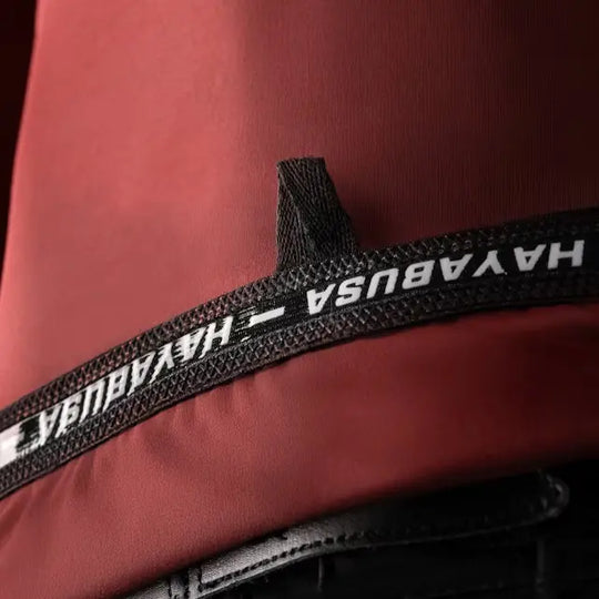 close-up van de binnenkant van de onderrand van een rode Hayabusa rashguard met herhaalde Hayabusa-letters en streepjes tussen de tekst