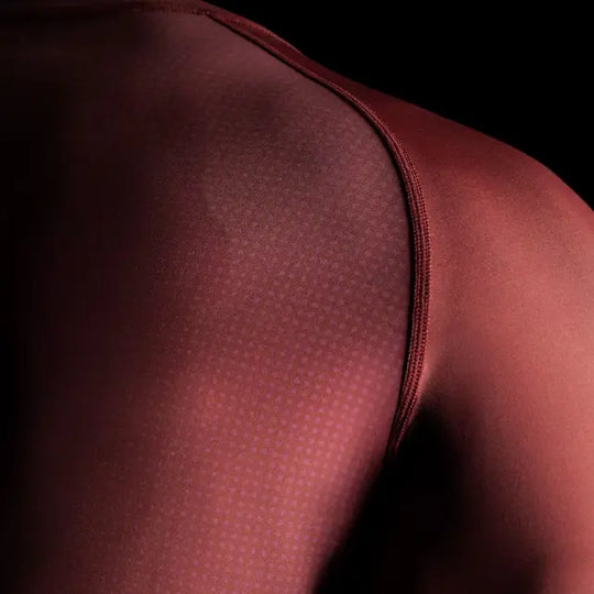 close-up van de schouder en een deel van de borst van een rode Hayabusa rashguard met zichtbare stiksels