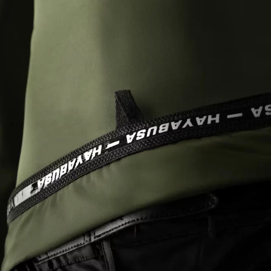 Detail van de groene Hayabusa Core rashguard met elastische tailleband en logo-afwerking
