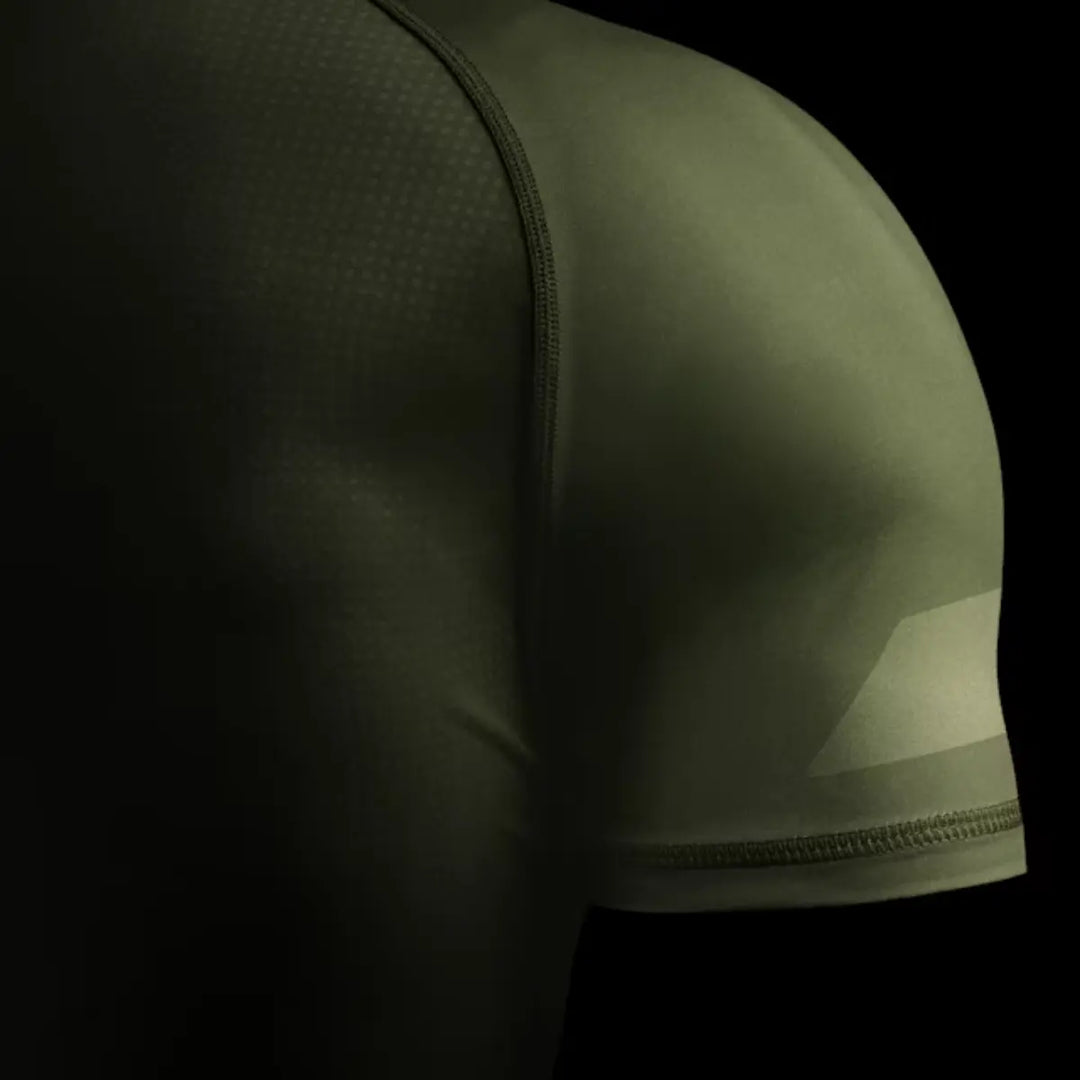 Close-up van groene Hayabusa rashguard met zichtbare naden en gladde stof voor vechtsporttraining.