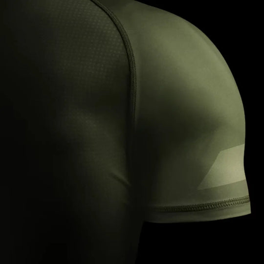 Close-up van groene Hayabusa rashguard met zichtbare naden en gladde stof voor vechtsporttraining.