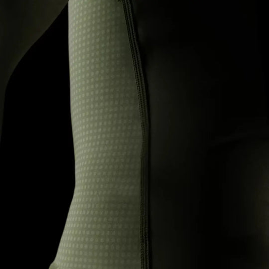 Close-up van de zijkant van de groene Hayabusa rashguard met zichtbare naad en geperforeerde stof voor optimale ventilatie.