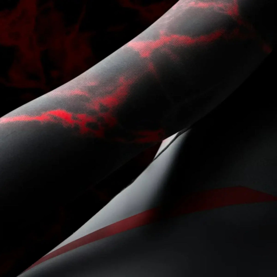 Close-up van de lange mouw met zwart-rode marmering en strakke pasvorm.