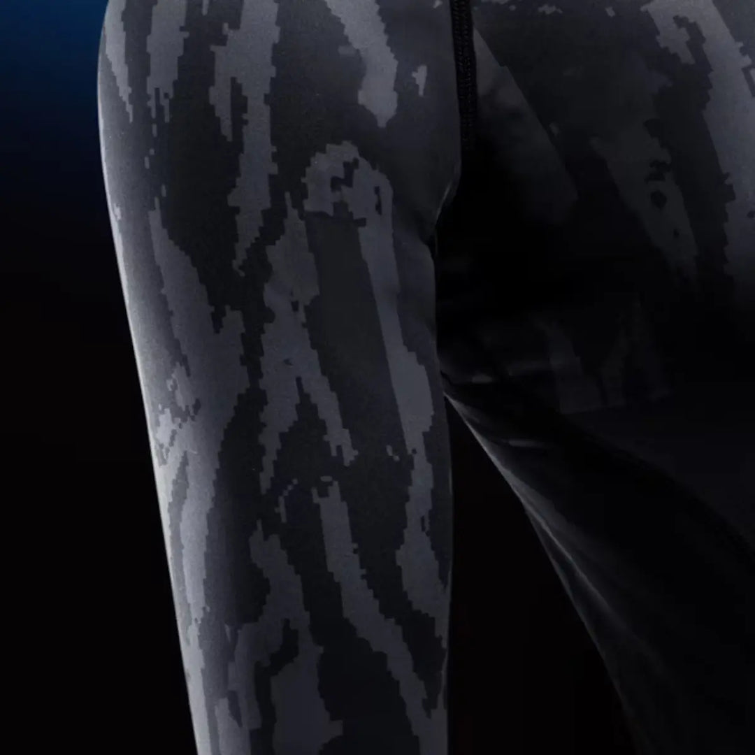 Close-up van de zwarte camo rashguard met strakke naden en subtiel camouflagedesign.