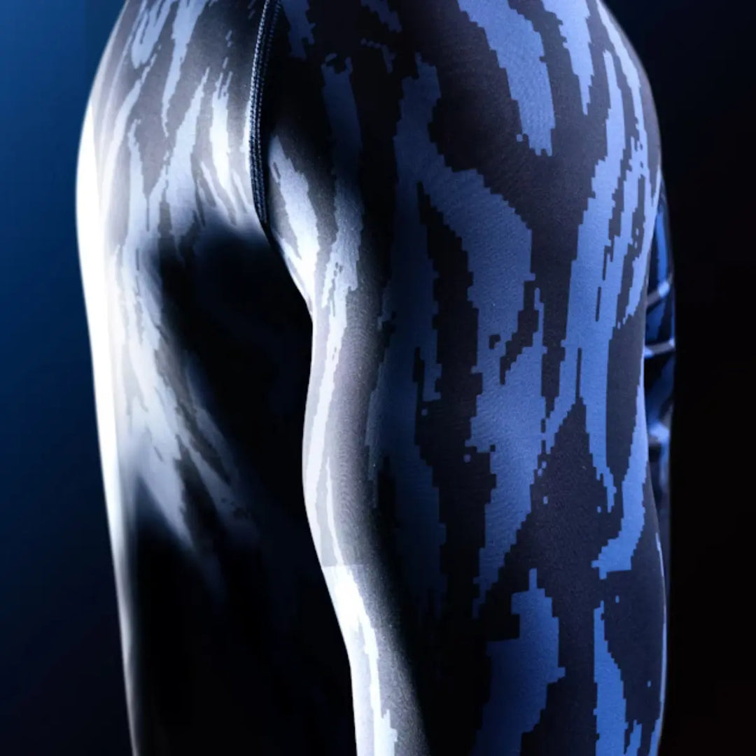 Close-up van de mouw van een Hayabusa rashguard met blauw-zwart camo patroon.