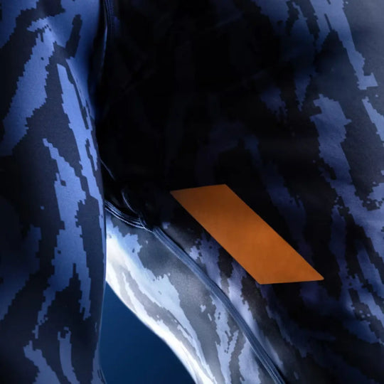 Detail van blauwe Hayabusa rashguard met camouflageprint en oranje accent