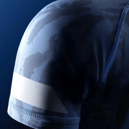 Close-up van de mouw van de Hayabusa Apex dames rashguard korte mouw in Crystal Blue, met camo-patroon en witte armbandprint