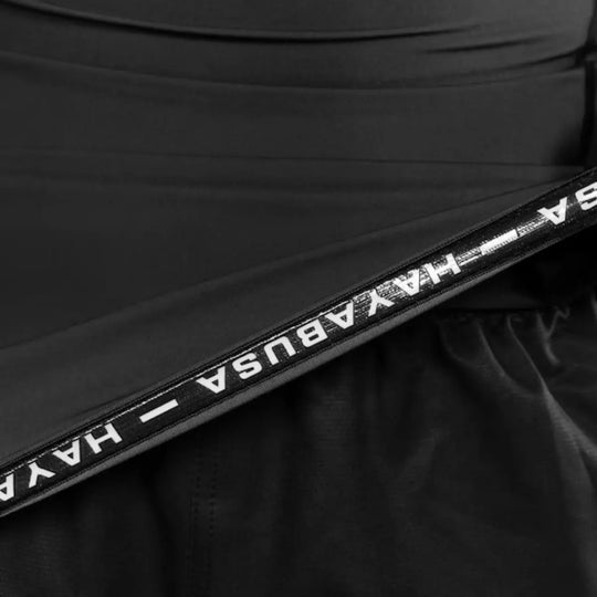 Close-up van de zwarte Hayabusa Apex dames rashguard met korte mouwen in Carbon Black, met zichtbaar elastisch detail en merklogo aan de binnenzijde.