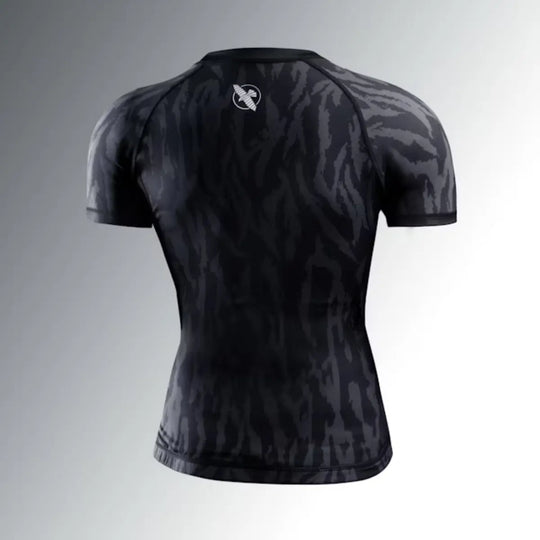 Achterkant van de Hayabusa Apex dames rashguard korte mouw in Carbon Black, met subtiel zwart-grijs patroon en wit Hayabusa logo in de nek.