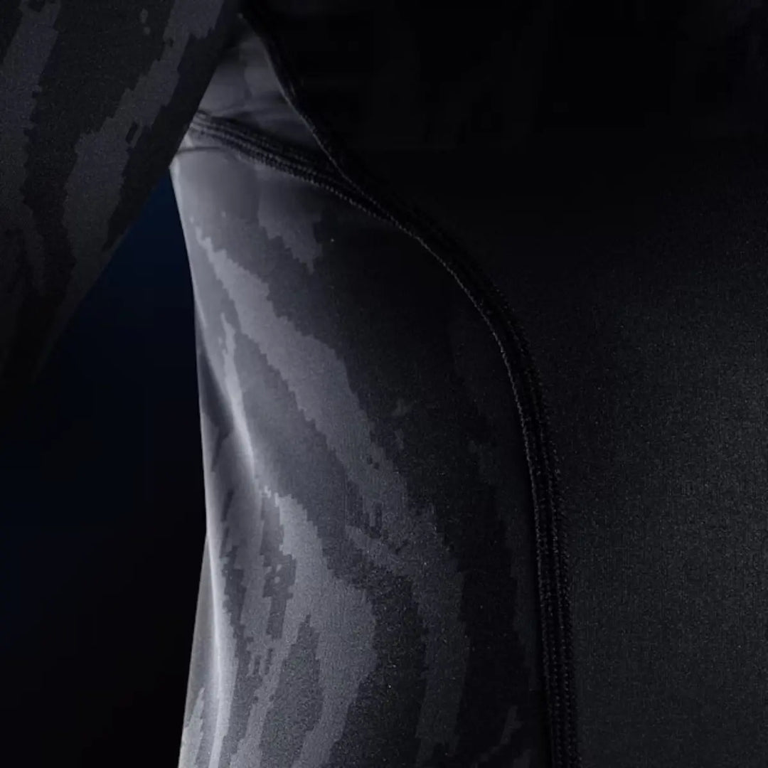 Close-up van de Hayabusa Apex dames rashguard korte mouw in Carbon Black, met zichtbaar stiksel en zwart-grijs camouflagepatroon.