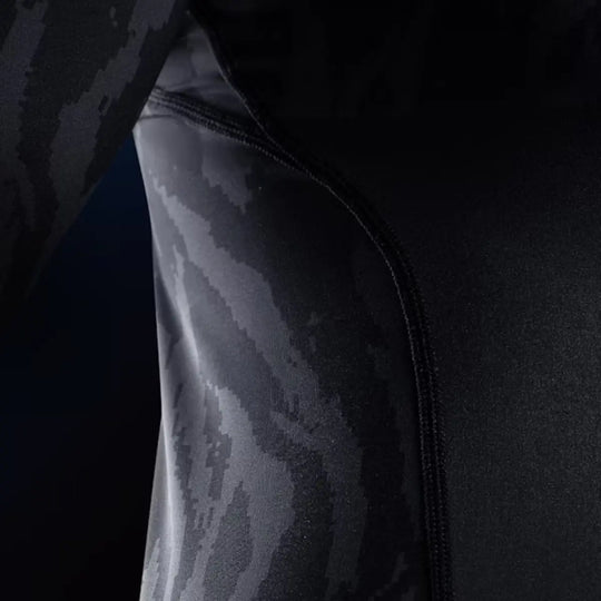 Close-up van de Hayabusa Apex dames rashguard korte mouw in Carbon Black, met zichtbaar stiksel en zwart-grijs camouflagepatroon.
