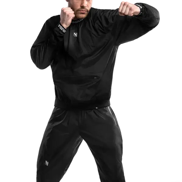 Een man traint in de Hayabusa Sauna Suit Zwart, ontworpen om zweetproductie te verhogen en vetverbranding te stimuleren tijdens intensieve workouts. De duurzame, lichtgewicht stof biedt volledige bewegingsvrijheid en comfort bij bokstrainingen en cardio.