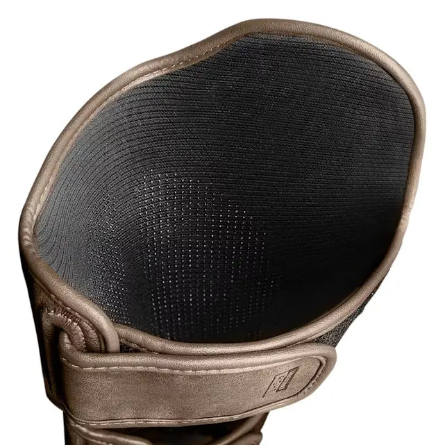 Binnenzijde van de Hayabusa T3 LX scheenbeschermer in bronskleurig leer, met geperforeerde zwarte voering voor ventilatie en comfort tijdens training.