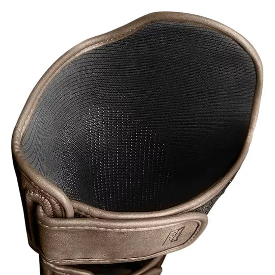 Binnenzijde van de Hayabusa T3 LX scheenbeschermer in bronskleurig leer, met geperforeerde zwarte voering voor ventilatie en comfort tijdens training.