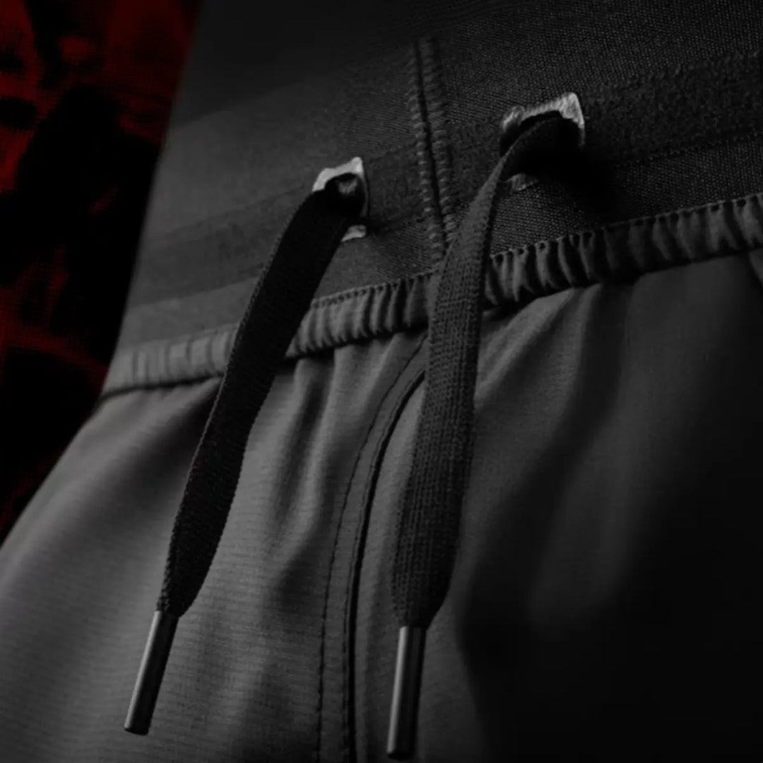 Detailfoto van de vetersluiting op de UFC BJJ Women’s Shorts. De zwarte koorden en metalen uiteinden tonen de verstelbare pasvorm. De stevige tailleband is duidelijk zichtbaar en ontworpen voor intensieve training. De foto heeft een donkere, professionele uitstraling.