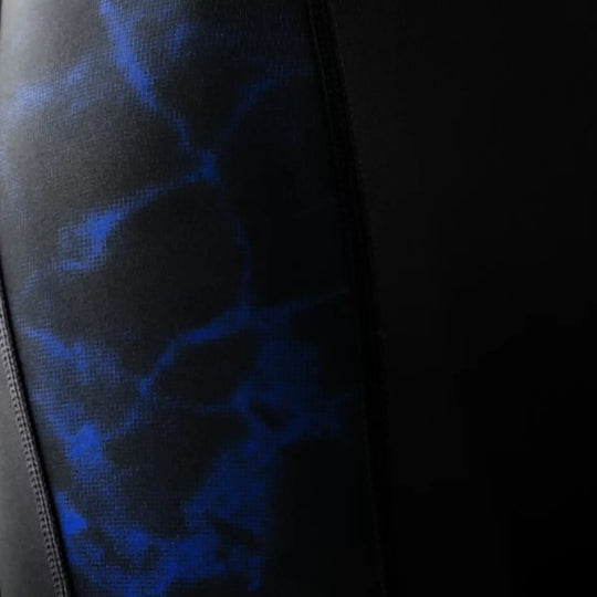 Close-up van het blauwe marmerpatroon op de zijpanelen van de shorts. De structuur van de stretchstof is duidelijk zichtbaar. De afbeelding laat de combinatie van flexibiliteit en duurzaamheid zien. Het patroon geeft de shorts een moderne, sportieve uitstraling.