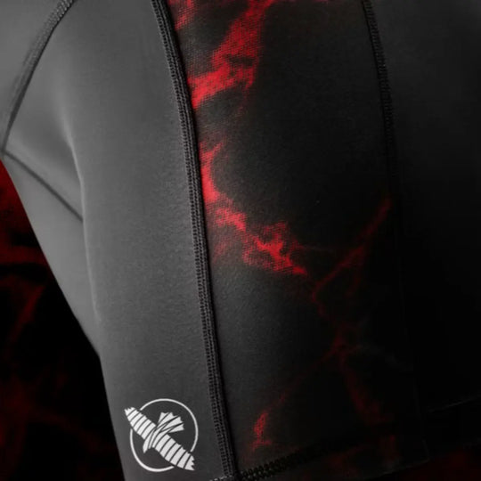 Detail van het Hayabusa-logo op de zwarte dames Vale Tudo short met rode accenten.