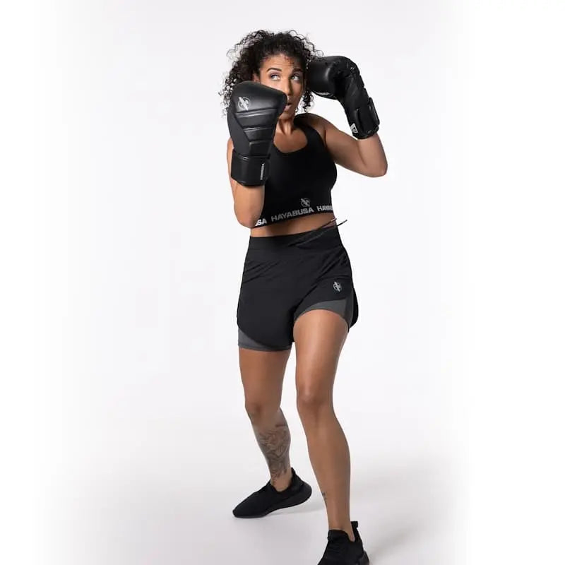 De Hayabusa Sport BH Zwart gedragen tijdens een bokstraining. De afbeelding laat zien hoe de sport-bh ondersteuning en bewegingsvrijheid biedt tijdens intensieve bokstraining en kickbokstraining.