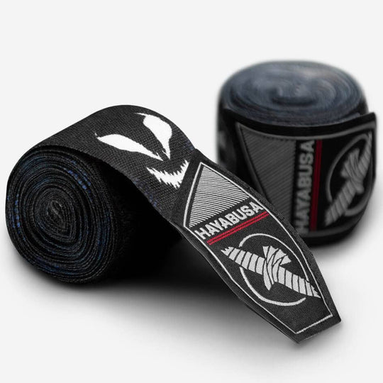 Close-up van een opgerolde handbandage, waarbij de klittenbandsluiting met het Hayabusa en Symbiote logo duidelijk zichtbaar is.
