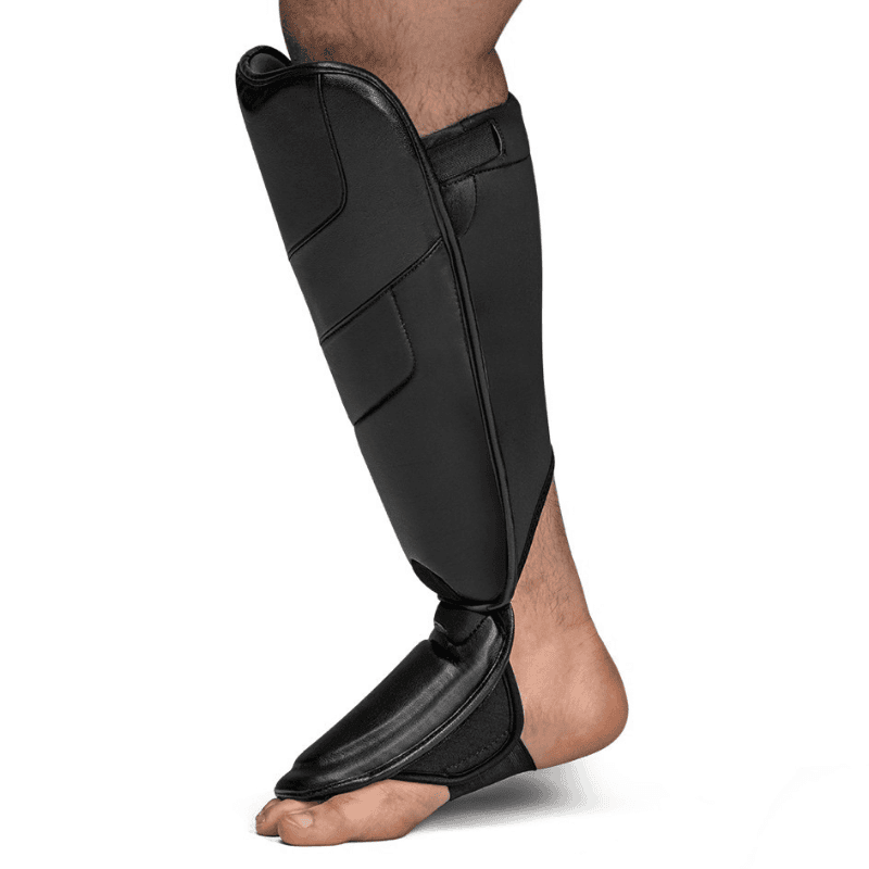 Zijaanzicht van een atleet die zwarte Hayabusa T3 Full Back Scheenbeschermers draagt.