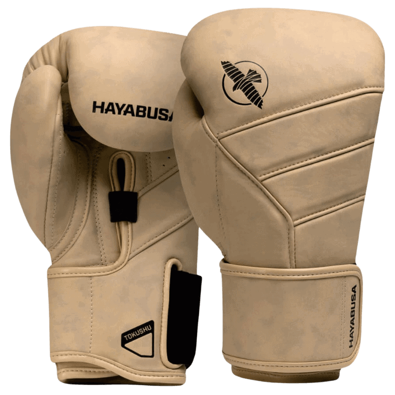 Een paar Hayabusa T3 LX bokshandschoenen in de kleur tan met het zwarte Hayabusa-logo op de bovenkant en het valklogo aan de zijkant, met klittenbandsluiting zichtbaar aan de onderkant.