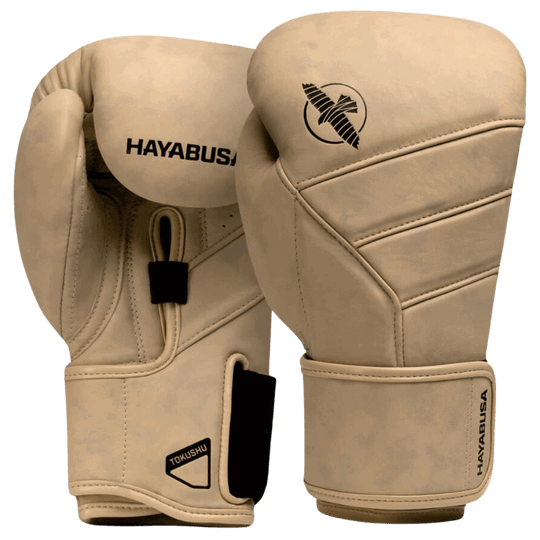 Een paar Hayabusa T3 LX bokshandschoenen in de kleur tan met het zwarte Hayabusa-logo op de bovenkant en het valklogo aan de zijkant, met klittenbandsluiting zichtbaar aan de onderkant.